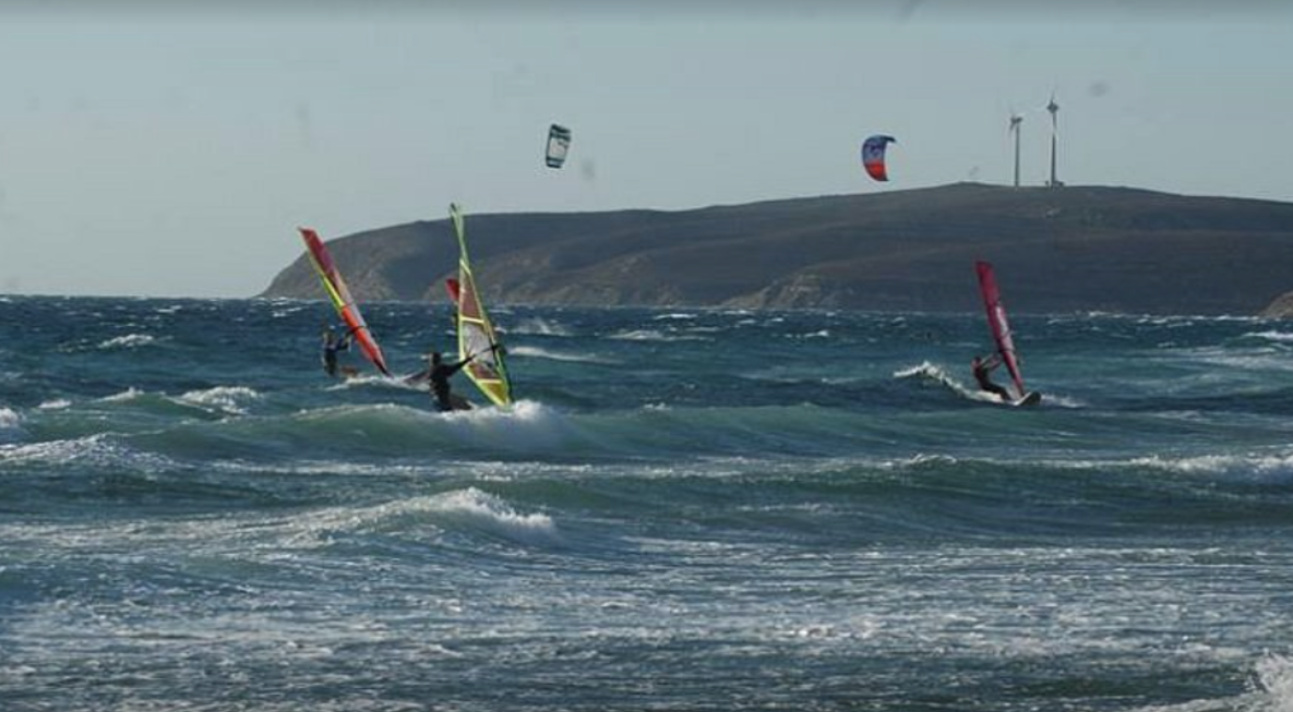 Kite surfers and windsurfers riding waves at Keros Beach